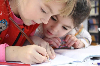 Kinder am Schreibtisch malend